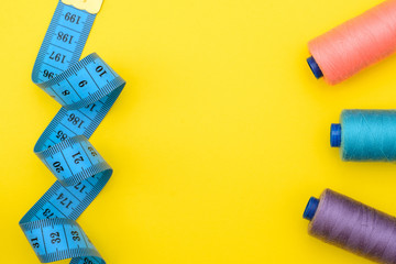 tool kit for cutting, sewing on yellow background with a blank space under an inscription in the middle. Top view, Flat Lay.