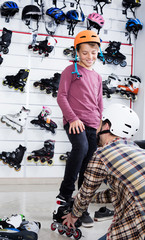 Father putting roller-skates on his son