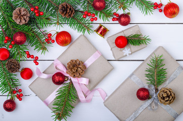 Christmas background with decorations and a gift boxes on a wooden white table, top view.
