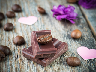 Decorations for Valentines day paper hearts, violets and chocolate coffee on rustic wooden background