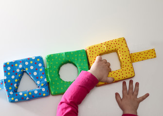 Obraz premium Child's hand, playing with montessori toys. Soft sorter