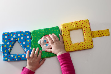 Child's hand, playing with montessori toys. Soft sorter