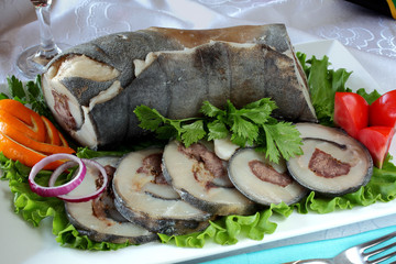 Fototapeta na wymiar Roll of leather, sheep fat,meat lamb with spices.Served cold with salad greens, onion.Uzbek cuisine.