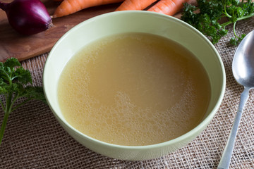 Chicken bone broth in a green soup bowl