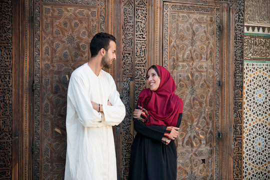 Arab couple in relationship talking and smiling in traditional clothing