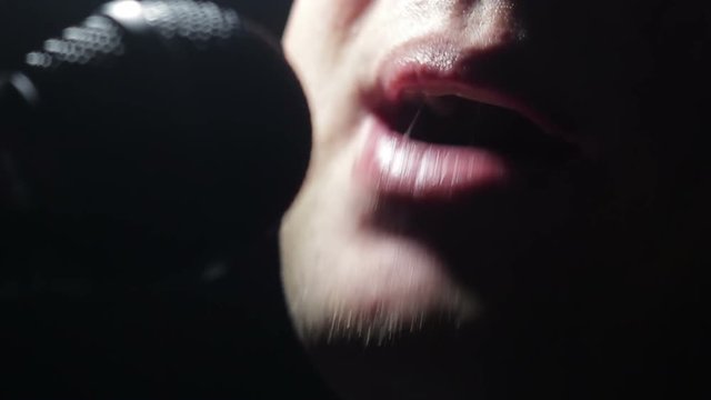 Man singing song in the dark. The singer sings a song in the light of soffits