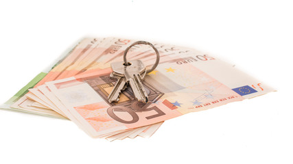 Keys to the apartment on the background of banknotes. Euro banknotes 50 fifty. Isolated money on white background.