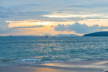 three traditional Thai boats at sea during a beautiful sunset