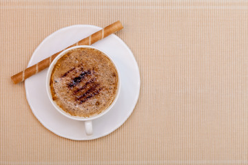 White cup coffe and waffle roll with cream on brown background