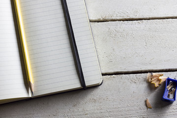 Caderno em branco aberto com lápis apontado amarelo em cima