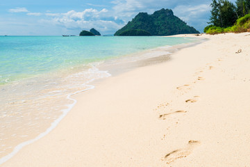 footprints in the sand along the sea on Poda island, Thailand