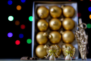Christmas baubles in a box against a background of Christmas lights. Christmas dinner wrapped in cardboard box on the background of the lamps.