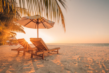 Sunset on Maldives island, water villas resort. Beautiful sky and clouds. Beautiful beach background for summer travel with sun, beach wooden jetty. Summer mood sun beach background concept.