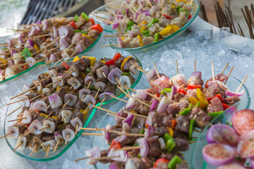Tropical meal with skewer sticks, fish and meat and vegetables background