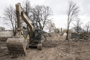 huge yellow shovel digger on demolition site
