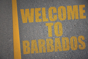 asphalt road with text welcome to barbados near yellow line.