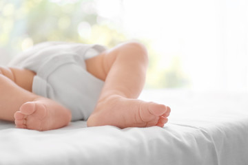 Cute baby lying on bed at home