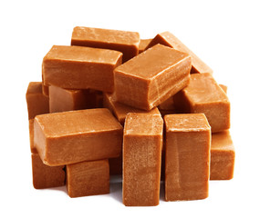 Delicious caramel candies on white background