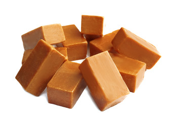 Delicious caramel candies on white background