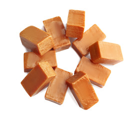 Delicious caramel candies on white background