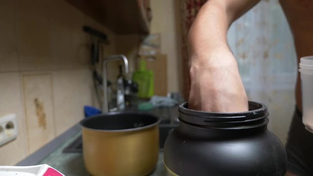 Slow motion. 4k. Young man making a protein shake at home. anonymously