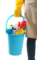 Woman holding bucket with cleaning products and tools on white background