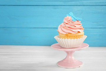 Stand with beautiful cupcake on table