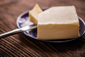 close up butter in a dish  on old wood background