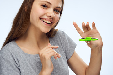 Young beautiful woman on white isolated background holds a spinner spinner, entertainment