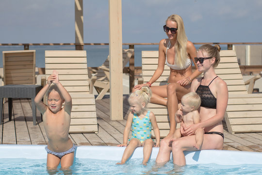 happy family having good time in blue  swimming pool 