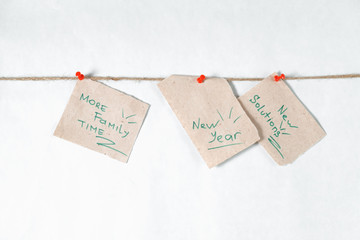 notes reminders and goals for the next new year on a linen rope with white background and red pins