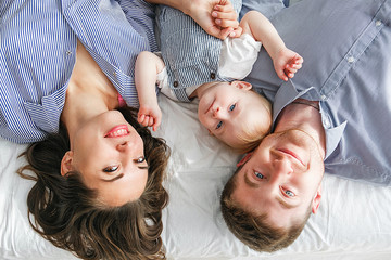 Family Lying Upside Down On Bed In Pajamas Together. Family look. Close-up portrait shot