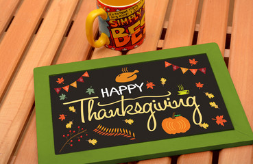 Happy thanksgiving drawing on chalkboard with colorful cup