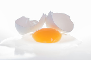 broken cracked white egg yolk on a white background