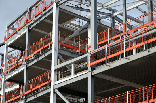 construction site of steel framed development with orange safety fencing