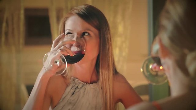 Two woman clink glasses and drinking red wine together friend on holiday dinner