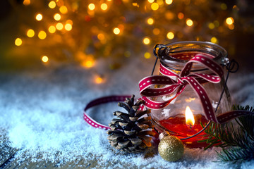 Advent  -  Burning candle in snow landscape with bokeh background