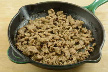 Stir fry strips of beef in cast iron frying pan skillet