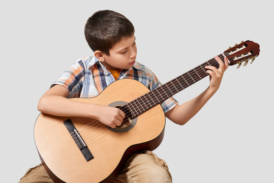 Boy is playing the acoustic guitar