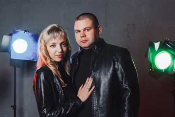 Couple in black dresses during image shooting in studio and spotlights