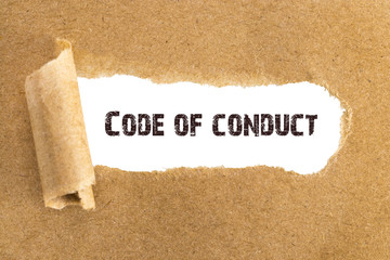 The text Code of conduct appearing behind torn brown paper