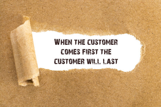 The text When the customer comes first the customer will last appearing behind torn brown paper