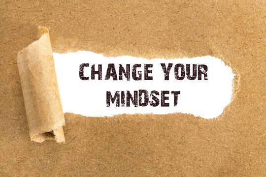The text CHANGE YOUR MINDSET  appearing behind torn brown paper
