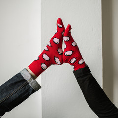 Feet in woollen socks. Pair relaxing with a cup of hot drink and warming up their feet in woollen socks. - 182909472