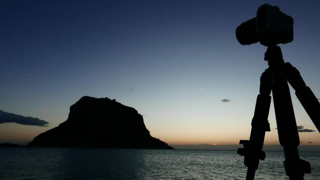 Professional camera taking picture film video from Monemvasia island at sunrise over sea surface, Greece Peloponnese Lakonia, Time lapse