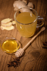 fresh ginger tea with honey on an old wood background