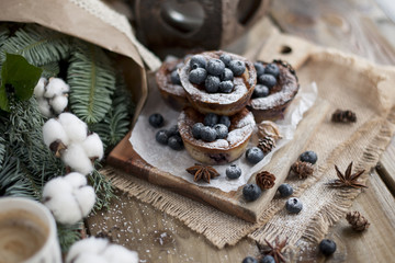 muffins with blueberries on a wooden background, bouquet of branches