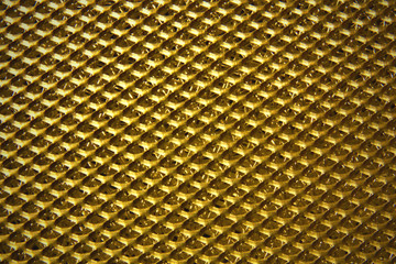 Gold color steel perforated sheet metal background.