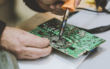 Man Repairing Electronic Circuitr using welder tool