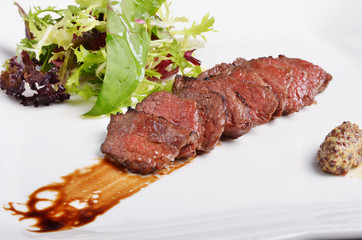 Grilled beef short ribs with salad on white plate 